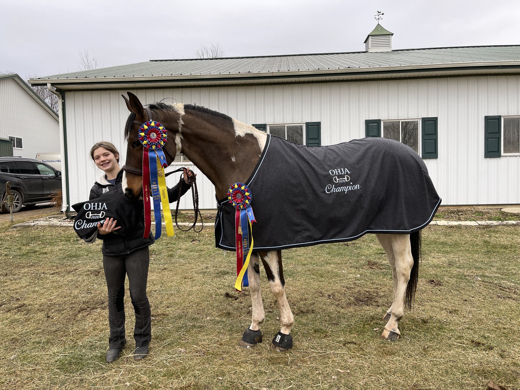 SiSi standing square in her full-length champion cooler, ribbons pinned along her neck.