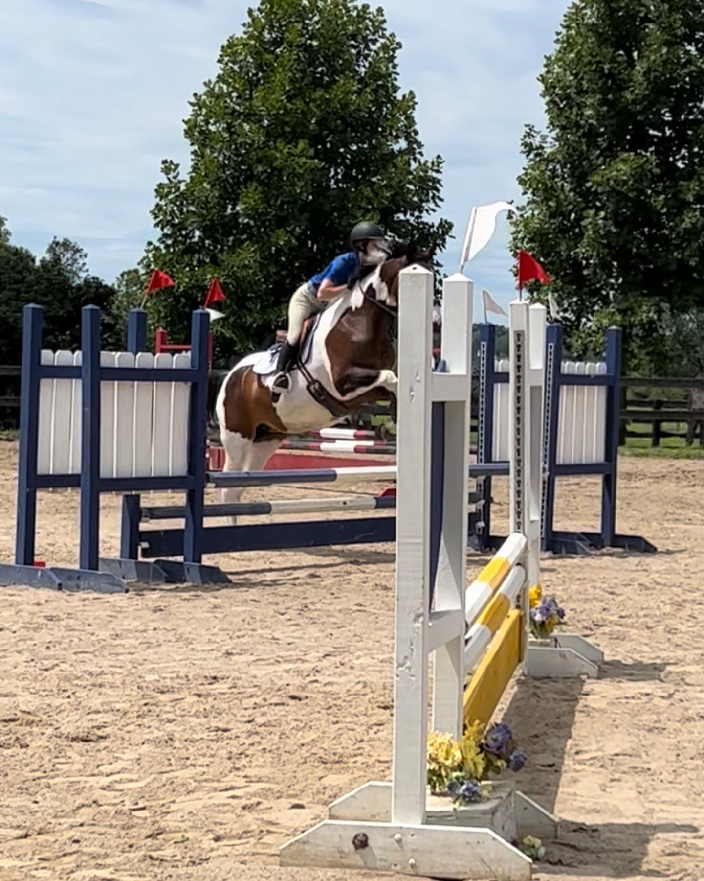 Rylee and SiSi mid-fence in an outdoor jumper round.