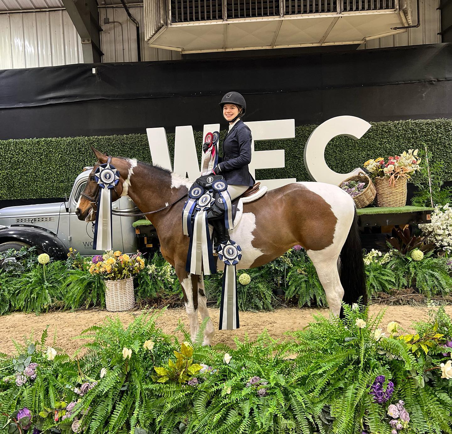 SiSi draped in championship rosettes and flowers with Rylee in the World Equestrian Center winners circle.
