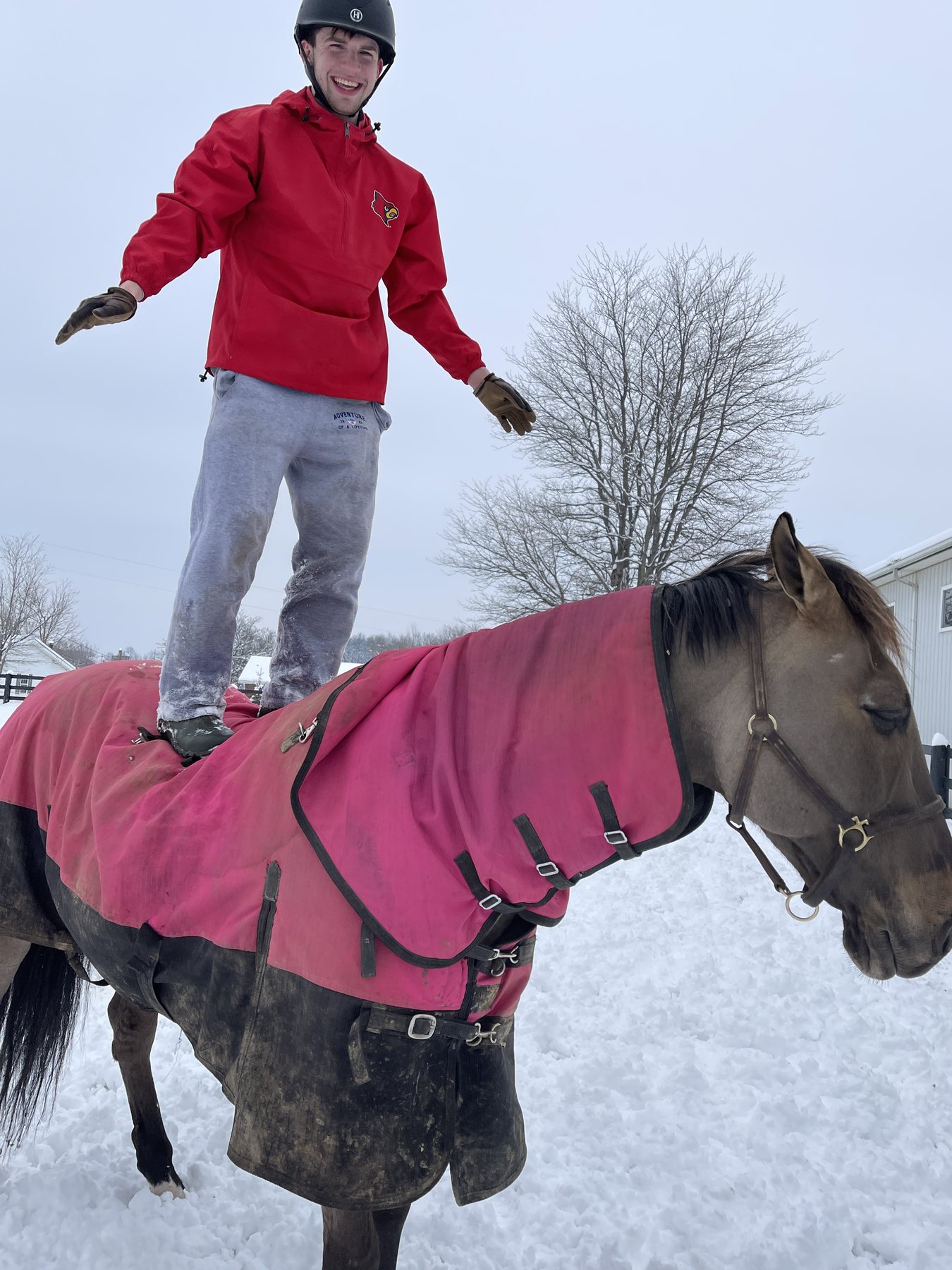 Rylee bareback on the teal-blanketed bay pinto beside the buckskin in the snow.