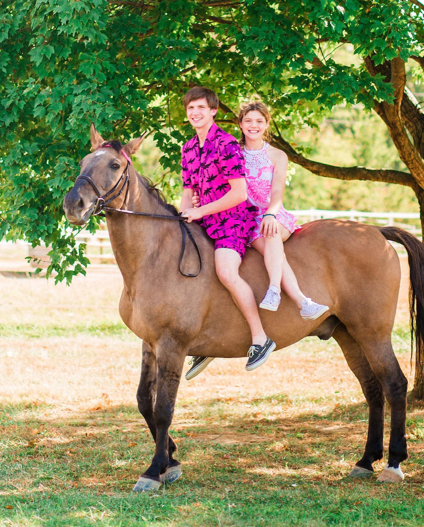 Kaleb and Rylee riding double bareback on a grulla dun in matching pink.