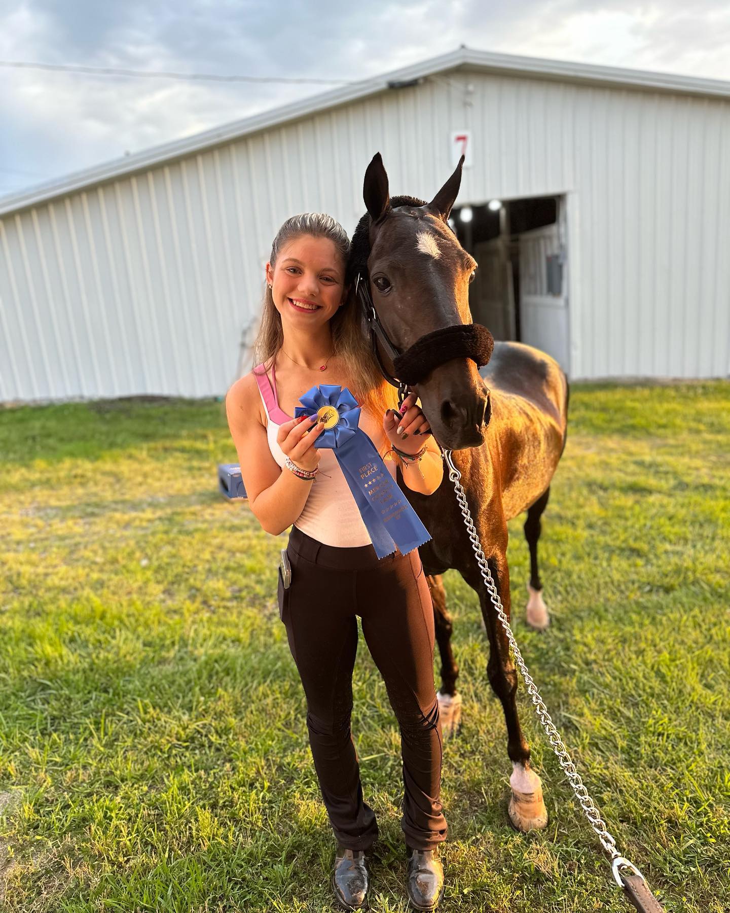 Rylee with a first-place ribbon and a dark bay at the Mercer County Fair.