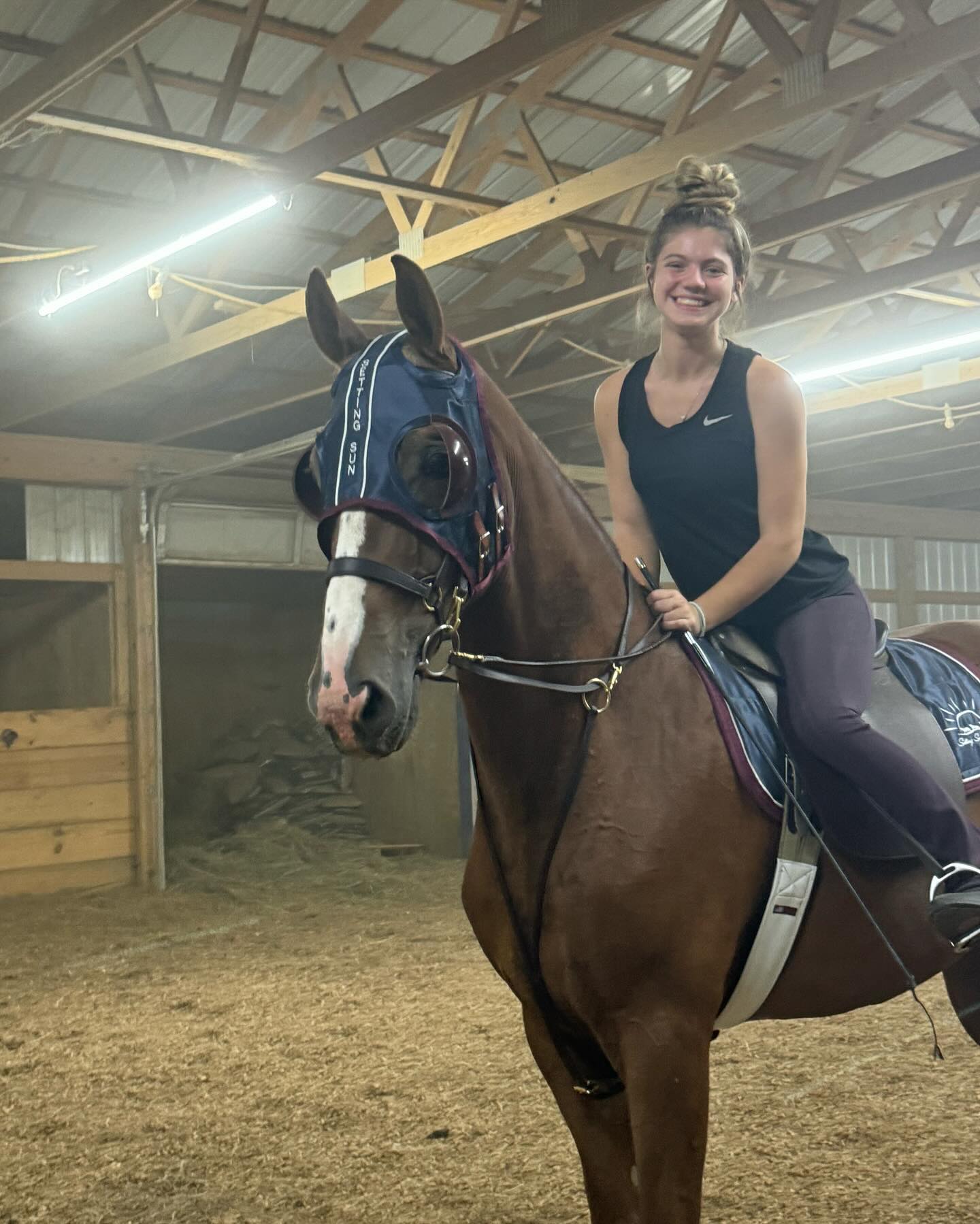 Rylee schooling a chestnut Saddlebred in a Setting Sun blinker hood in the indoor arena.