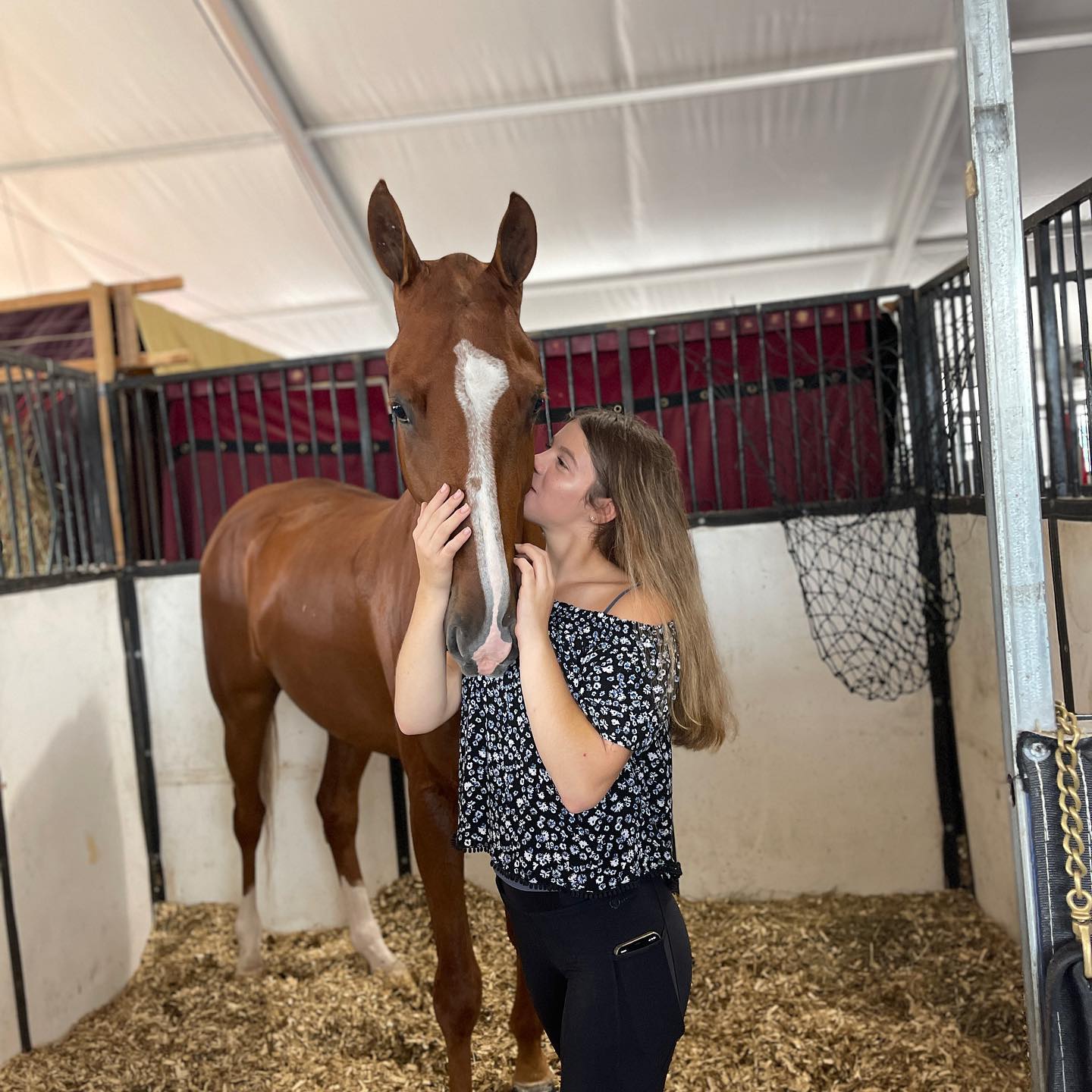 Rylee kissing a chestnut in the show-stall tent.