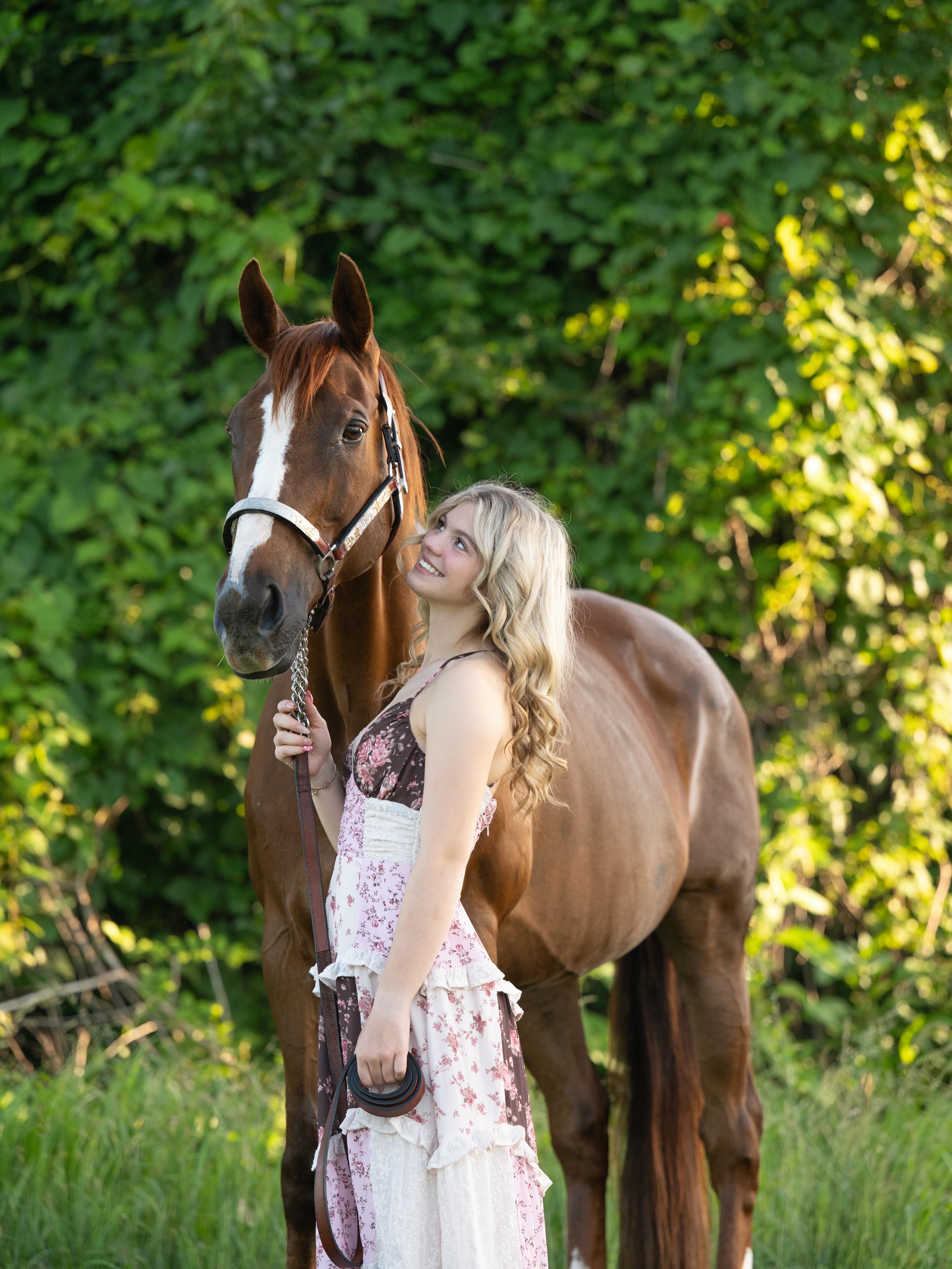 Rylee with a red chestnut in a silver show halter in a professional portrait.