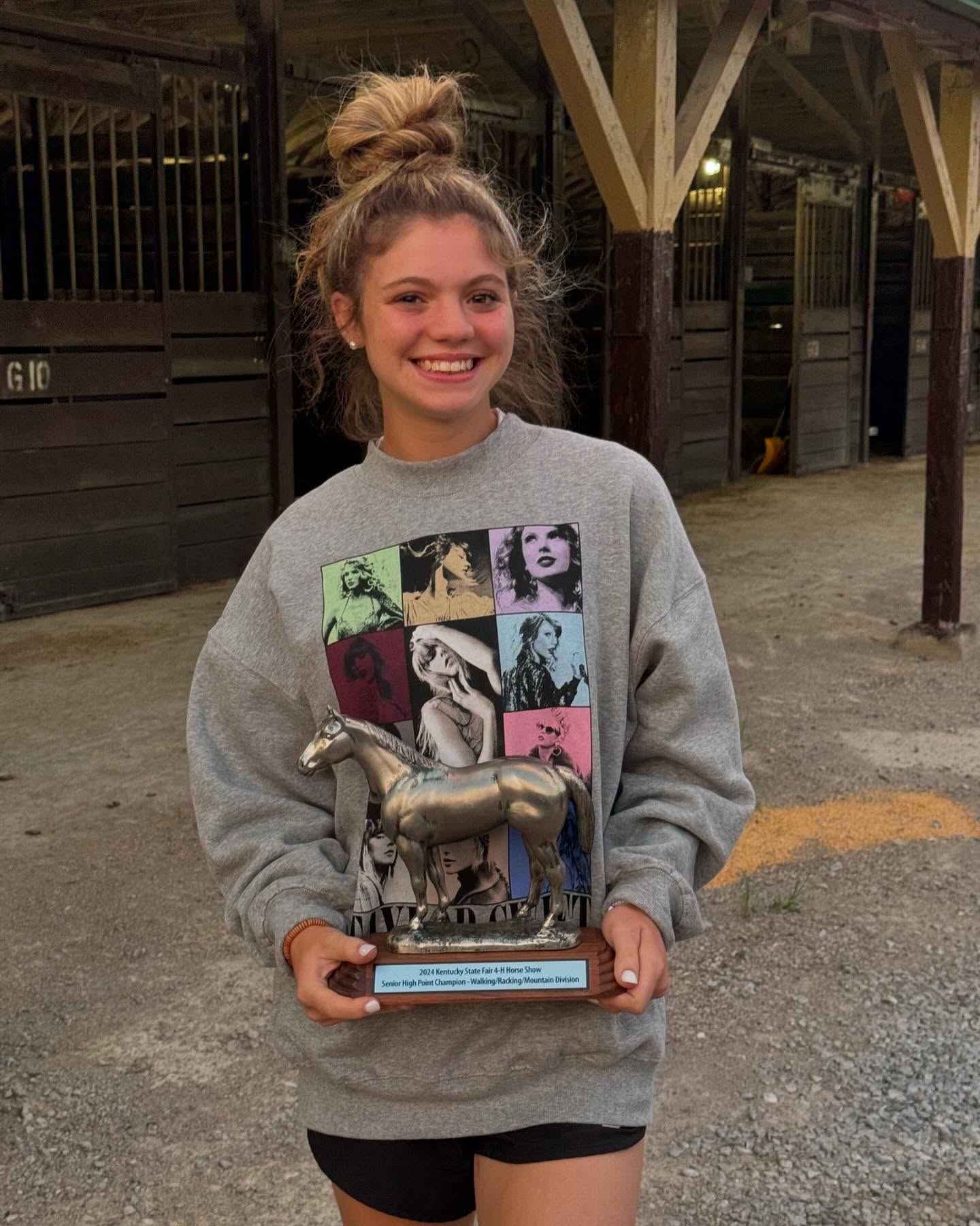 Rylee with the 2024 Kentucky State Fair 4-H Senior High Point Champion trophy at the stalls.