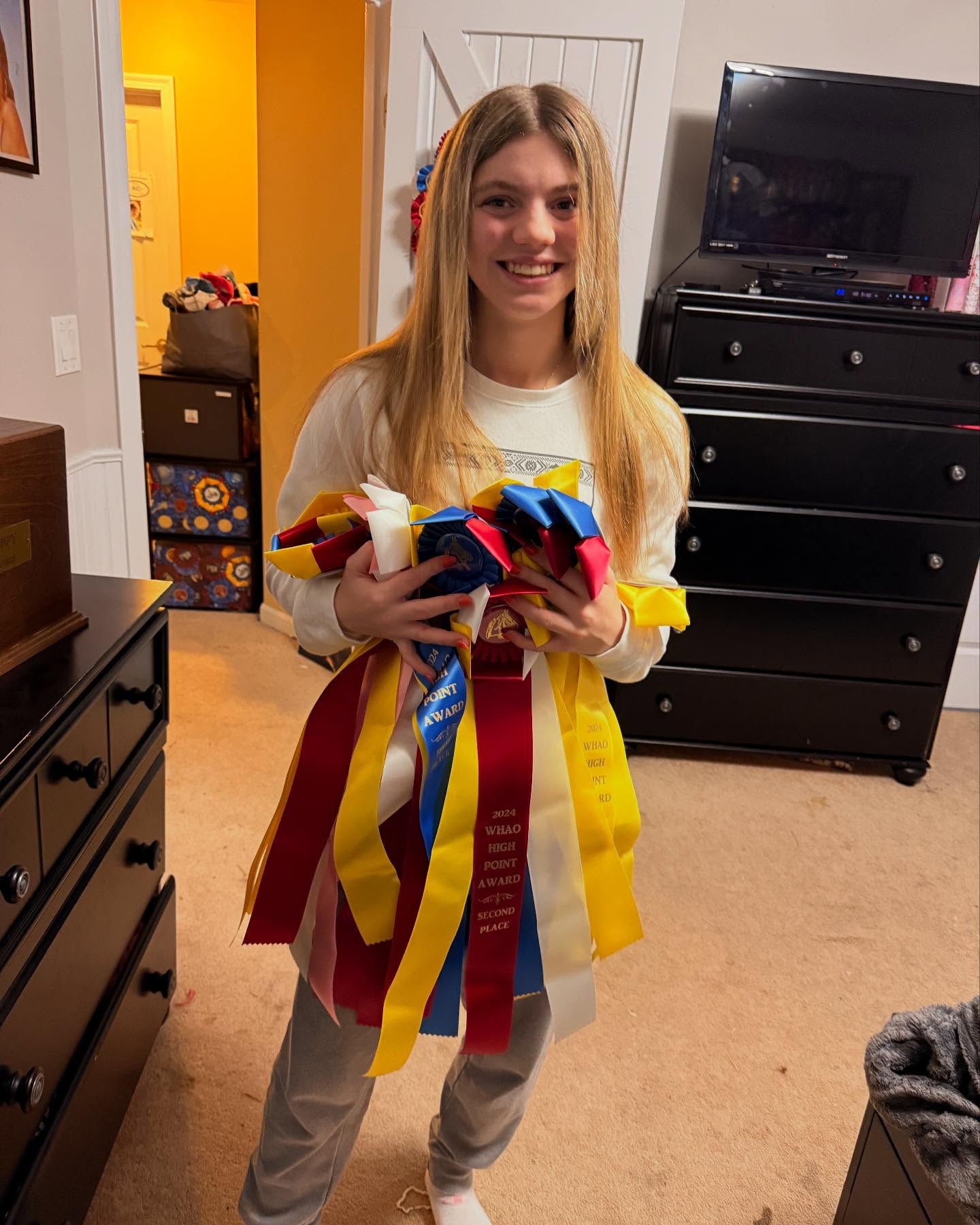 Rylee with an armful of 2024 WHAO High Point rosettes at home.