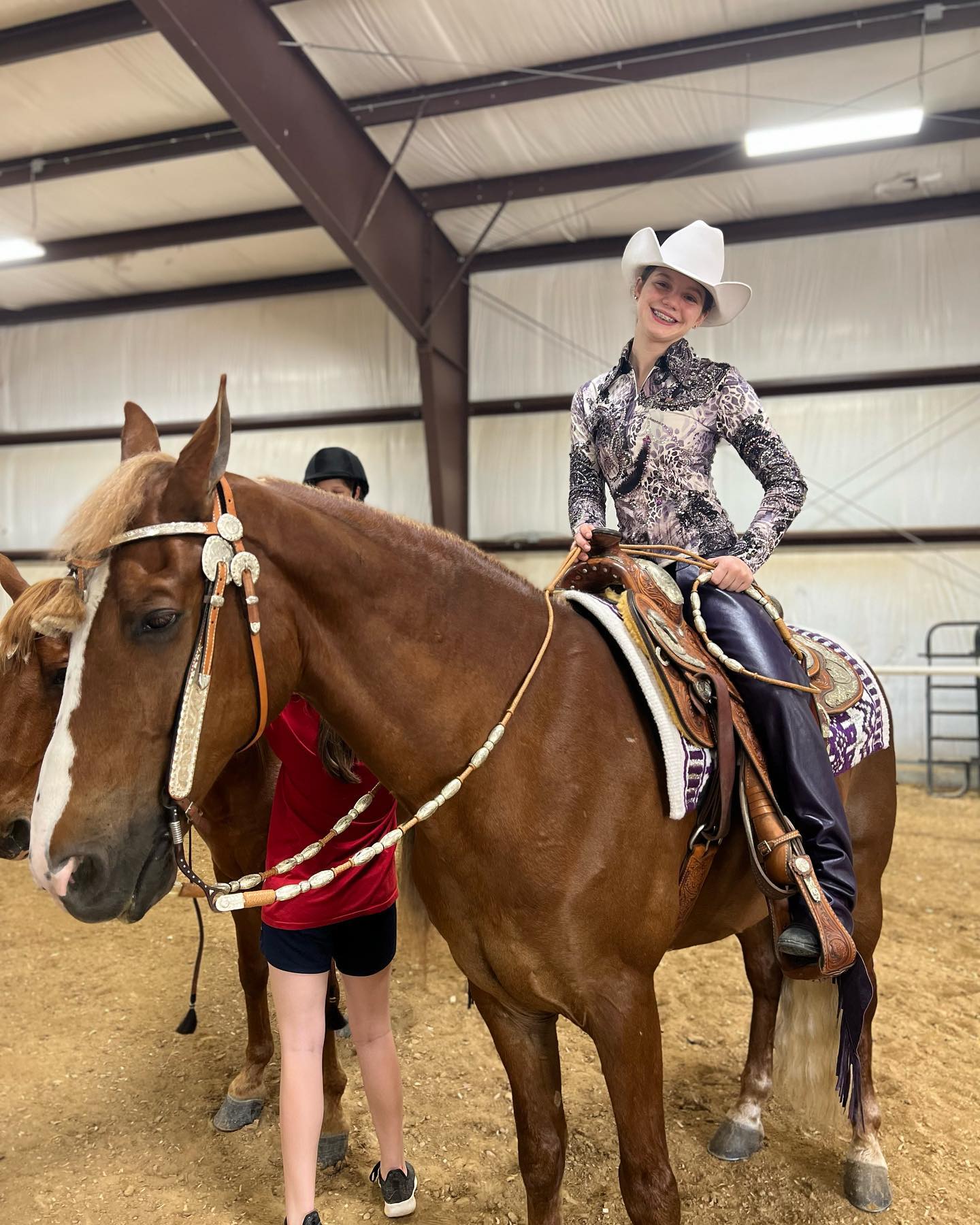 Rylee in a white cowboy hat and show shirt with a flaxen-maned sorrel under western tack.