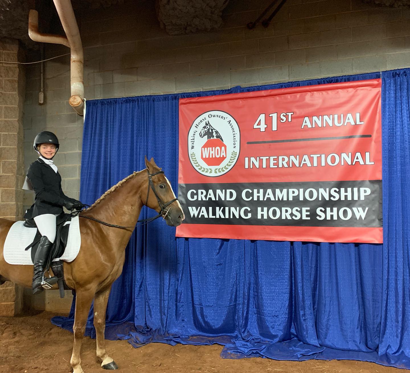 Rylee mounted before the WHOA 41st International Grand Championship banner.